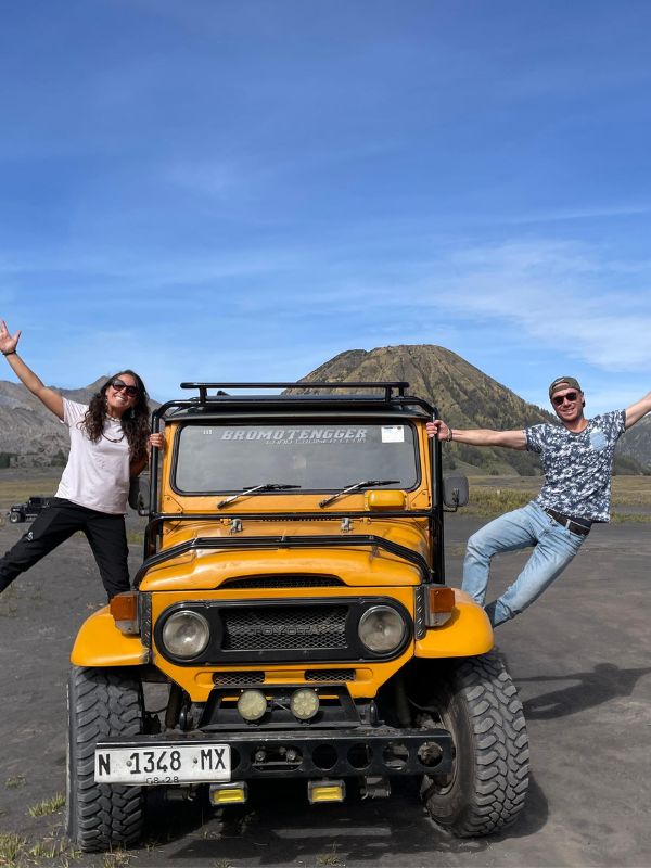 Guests standing beside a jeep in the Mount Bromo Sea of Sand during a private East Java tour