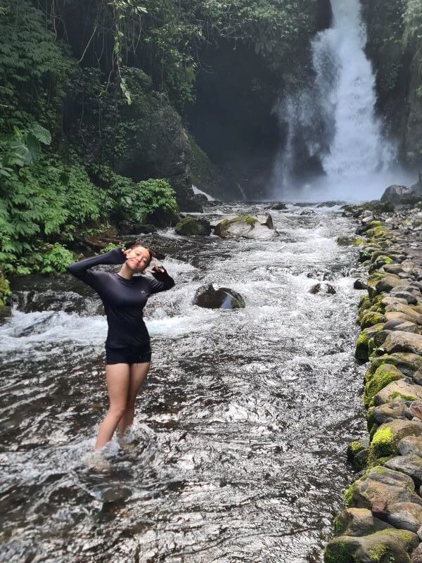 Guest standing at a hidden jungle waterfall during a private East Java tour